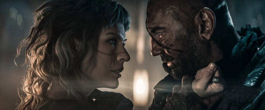 Milla Jovovich and Dave Bautista in In The Lost Lands (2025).